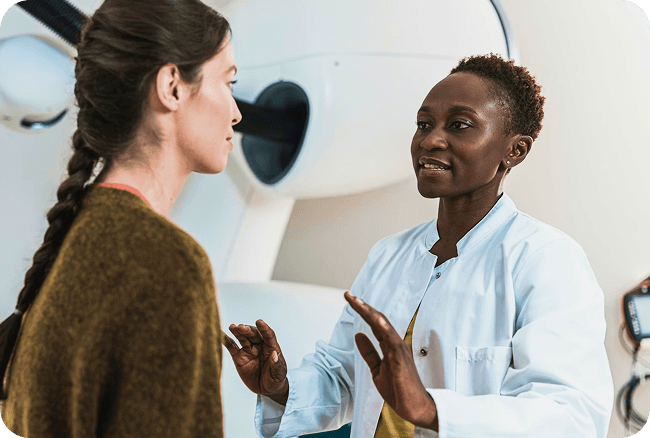 A woman wearing a white blouse talking to another woman